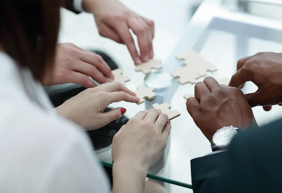 mains de collaborateurs qui assemblent un puzzle